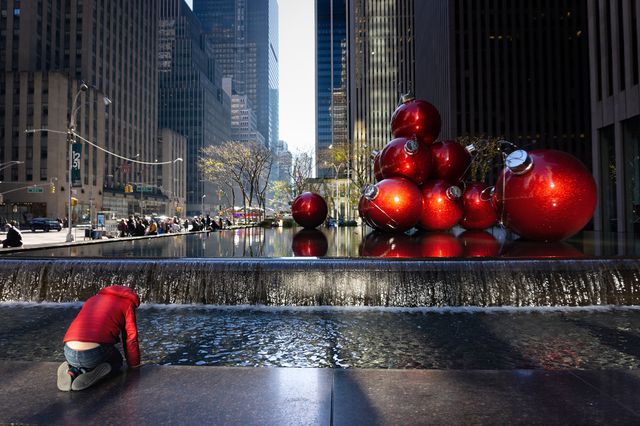 A photo of a person kneeling in front of statue in Midtown